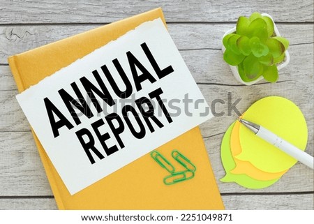 Annual Report . yellow notepad. torn paper with text.