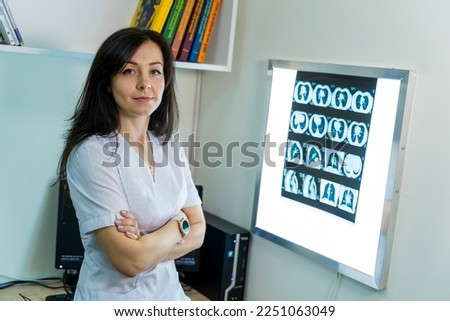 Doctor explaining an x-ray image near enlighted board.