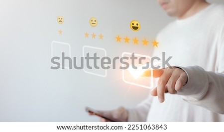 A customer presses a smiley face emoticon on a virtual touch screen. Customer service appraisal concept