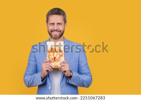 positive guy hold gift box in studio. guy with gift box for holiday. photo of guy holding gift