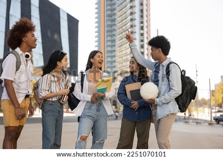 multiracial group of college students walking out of college