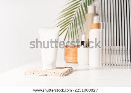 White plastic mockup cosmetic, cream tube standing on a bathroom shelf. Studio photography.