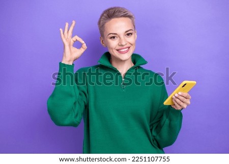 Photo of satisfied attractive freelancer blonde short hairdo woman hold phone show okey sign recommend this job isolated on purple color background
