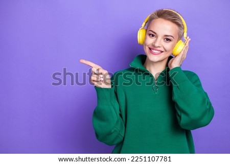 Photo of pretty positive girl toothy smile hand touch headphones direct finger empty space isolated on violet color background