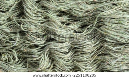 Threads of natural organic sheep wool. Unwound skein of olive green knitting yarn.