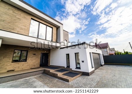 Cozy and modern house with garage and cobblestone driveway. Modern architecture. Royalty-Free Stock Photo #2251142229