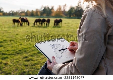 Pencil drawing. Woman artist sketching horse outdoors. Illustrator making sketch Royalty-Free Stock Photo #2251145097