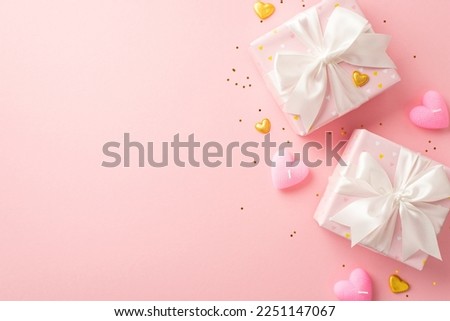 Valentine's Day concept. Top view photo of present boxes with white ribbon bows golden hearts candles and sequins on isolated pastel pink background with empty space