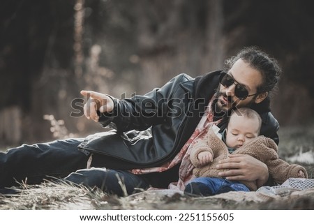 New born fall family photo shoot in forest. Cool dad with sunglasses pointing things out to his newborn baby