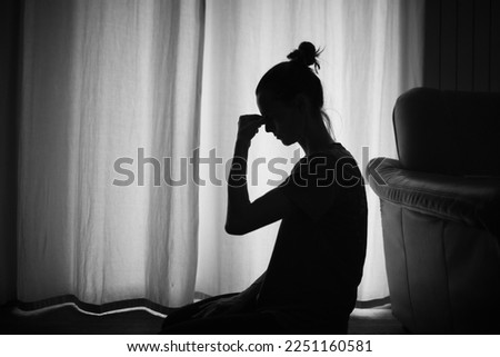 Silhouette of a tired and stressed woman indoors
