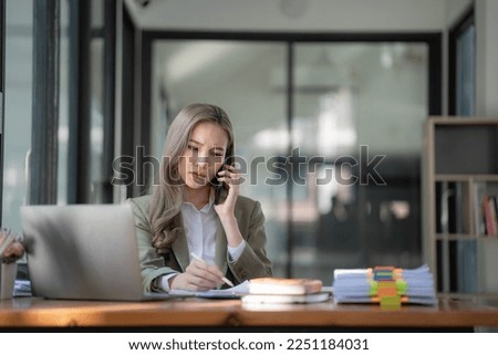 Stressed millennial Asian businesswoman or female manager having a serious phone call with her business client while working in the office. Royalty-Free Stock Photo #2251184031