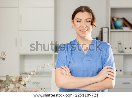 Waist-up portrait of woman medic standing in physician's office in clinic. Royalty-Free Stock Photo #2251189721