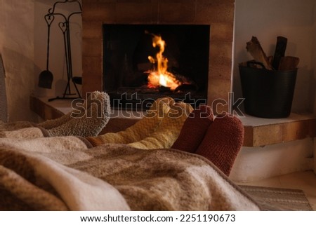feet of unrecognizable people with winter socks in the warmth of the fireplace - Concept winter, home comfort