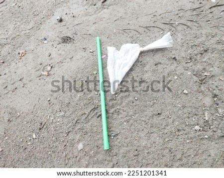 plastic and straws used for iced drinks are disposed of on wet ground