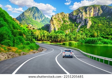 Road view in beautiful nature landscape. Car driving on road. highway passing through green mountains. highway scene in spring. Travel view in green mountain in summer. Road scenery in colorful forest Royalty-Free Stock Photo #2251205681