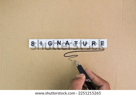hand holding a pen and signing with the word Signature alphabet letters. concept of agreement or contract.