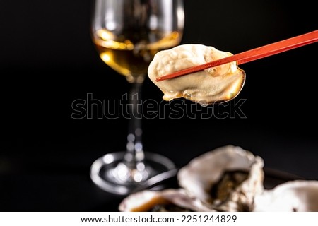 I photographed very fresh raw oysters and white wine against a black background.