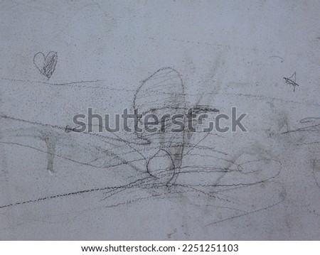 Children pencil drawing on a dirty white wall in kindergarten