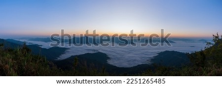 Beautiful landscape on the mountains at sunrise. Spectacular view in foggy valley covered forest under morning sky. Panorama Picture
