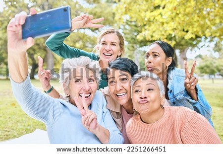 Senior people, friends and phone for selfie at the park together with smile and peace sign in the outdoors. Happy group of silly elderly women smiling for photo looking at smartphone in nature