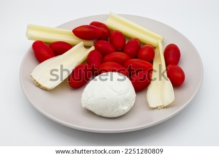 Mozzarella cheese with tomatoes and celery isolated on white background.