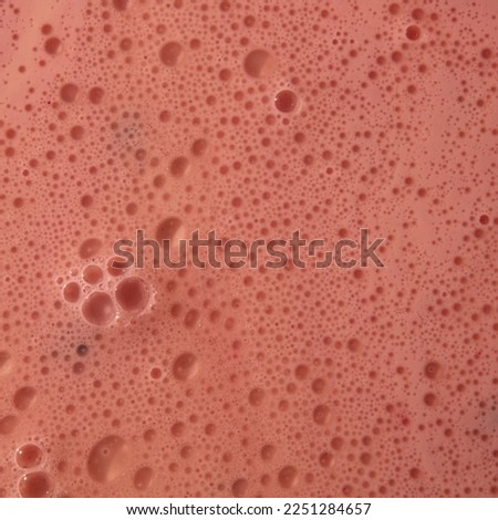 Small and large bubbles of pink sparkling wine in a champagne gl