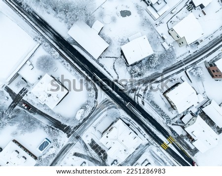 Aerial view of town with snow covered houses. Roof tops with snow on residential buildings in Switzerland.