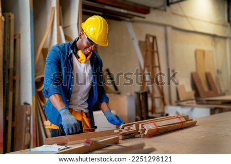 African American carpenter man look happy to work with timber in factory workplace in concept of happiness environment for worker increase quality of work.