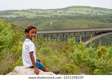 Young boy seen sitting alone in nature