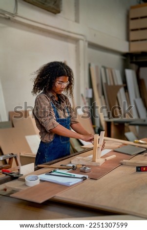 Asian wood worker woman stand and prepare to set and produce wood product such as chair or other in workplace area.