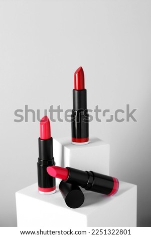 Different beautiful lipsticks on light gray background