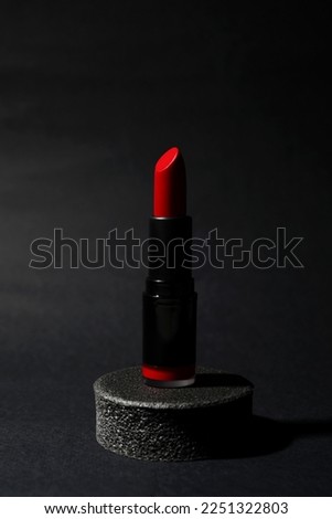 Beautiful glossy red lipstick on black background