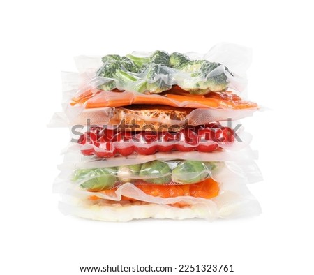 Stack of vacuum packs with different food products on white background Royalty-Free Stock Photo #2251323761