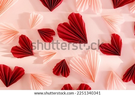 Happy Valentine's day ! Stylish pink and red hearts flat lay on pink paper background. Creative modern valentines hearts cutouts composition. Love background