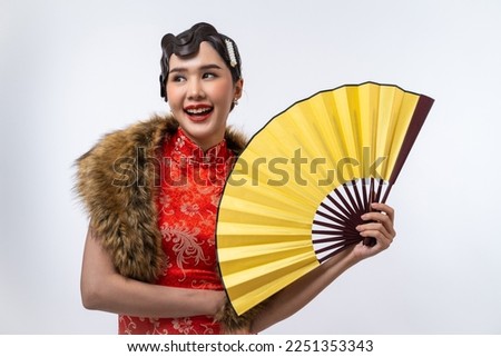 Beautiful Asian woman wearing cheongsam with fur cape holding gold fan isolated on white background, Happy Chinese New Year.