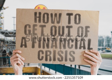 The phrase " How to get out of a financial crisis " is on a banner in men's hands with blurred background. Data. Invest. Disaster. Entrepreneur. Global. Inflation. Lost. Poverty. Unhappy. Capitalism