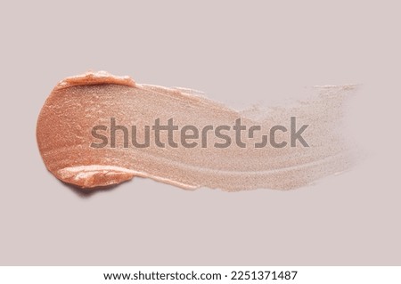 Shimmering lip gloss or balm isolated on beige