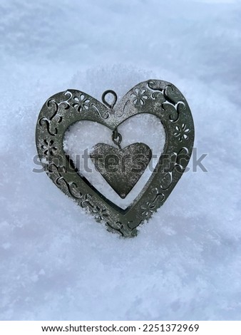 Brushed metal heart on a snow background offered on Valentine's Day in February