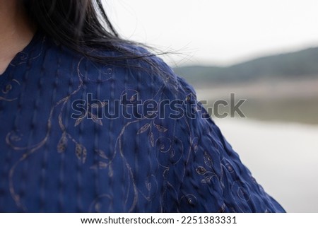 The details of women's cloth. Her face is not seen in photo.