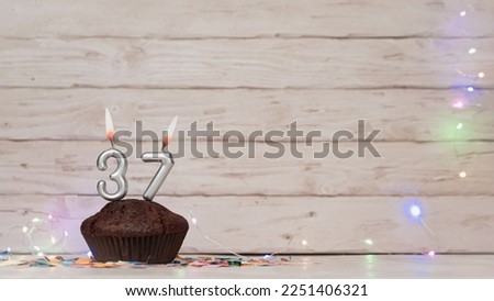 Festive card Happy Birthday with number of burning candles. Beautiful background copy space, happy birthday with digit number 37