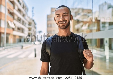 Young african american man smiling confident wearing backpack at street Royalty-Free Stock Photo #2251421651