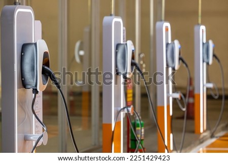 EV charging an electric car. Power supply for electric car charging. Socket for electrical car battery charger. EV car charging station in parking. Nature energy, Clean energy, Green eco concept. Royalty-Free Stock Photo #2251429423