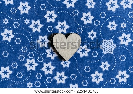 Wooden heart on a colorful ornate background and empty space