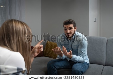Young married couple husband and wife sitting at home having problems in their marriage and a cold relationship. A boyfriend and a girlfriend have an argument about spending too much money. Royalty-Free Stock Photo #2251450823
