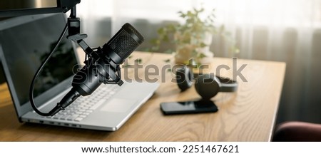 workplace of content creator with microphone, laptop and headphones. home studio for podcasting, online streaming, radio broadcasting. banner with copy space