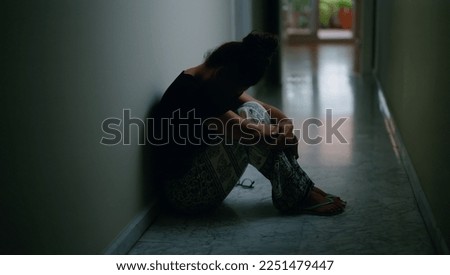 Middle age hispanic woman suffering for domestic violence with bruise on eyes sitting on floor at home Royalty-Free Stock Photo #2251479447
