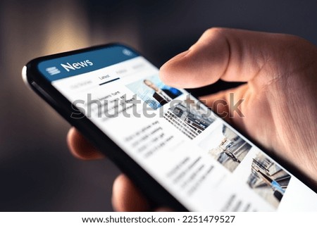 News feed in phone. Watching and reading latest online articles and headlines from smartphone newspaper mobile app. Daily digital information portal and publication. Media and press on internet. Royalty-Free Stock Photo #2251479527