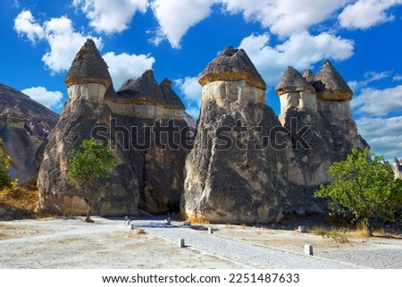 Picturesque natural stone statues against the blue sky in Cappadocia. Goreme National Park, district of Nevsehir, Kapadokya, Turkey                          Royalty-Free Stock Photo #2251487633