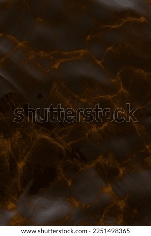 The texture of the water. An abstract photograph of the reflection of light and shadows from the surface of the water and the waves in dark brown gray tones. Background.