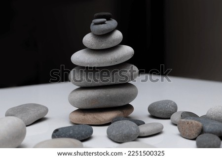 Gray flat pebble stones are stacked one on one. cairn